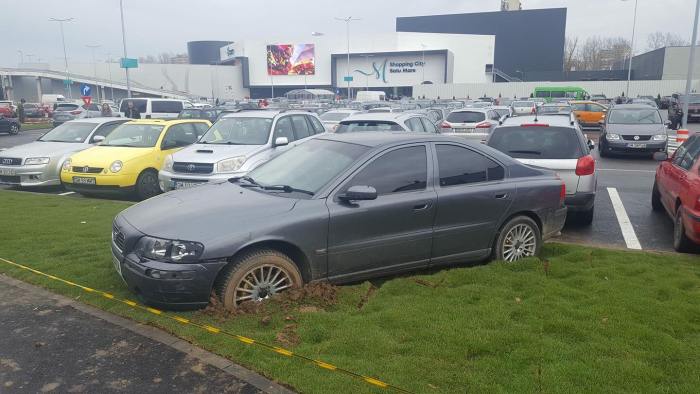 FOTO. Mașina polițistului, împotmolită în gazon la mall, fără asigurare și ITP