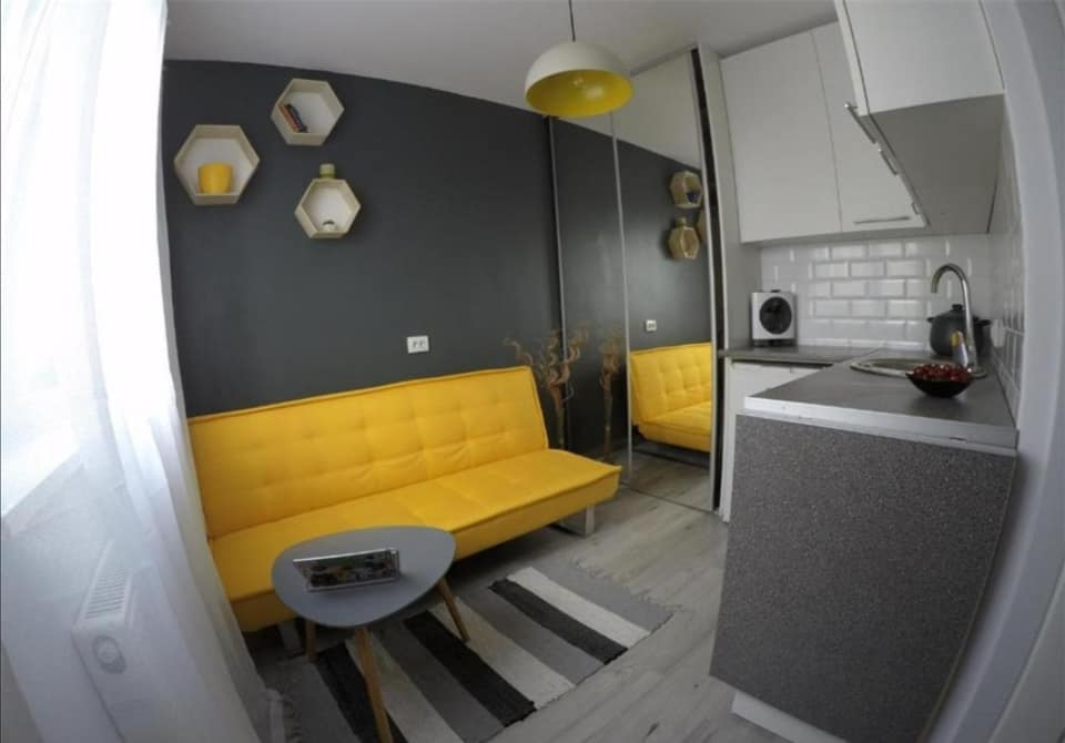 FOTO. Celebra garsonieră cu canapea galbenă, scoasă la vânzare. Ce preț cere proprietarul