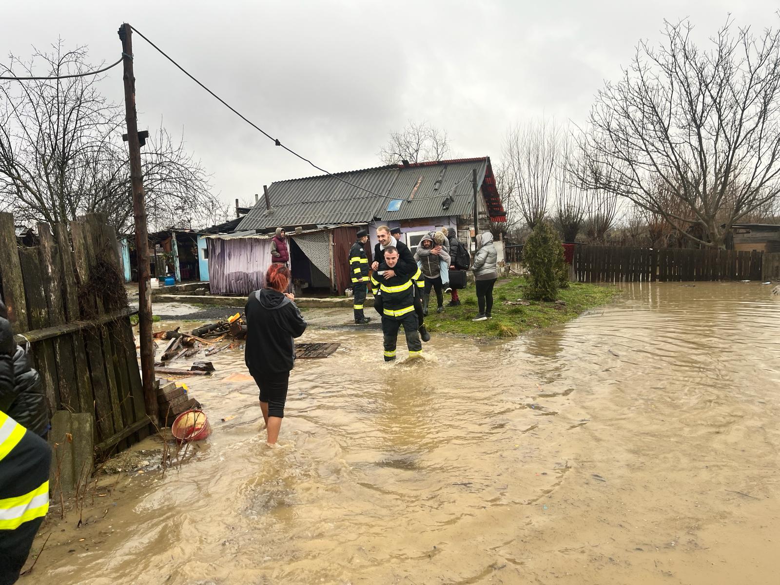 Imagini virale din țară. Dezbateri printre internauți după ce pompierii au cărat în spate tinerii prin apa până la glezne